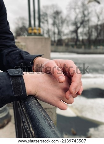 The hands of a man who stands waiting