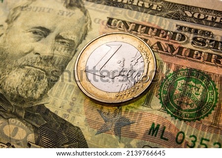 Poland — March 09 2022: In this photo illustration 1 euro coin (€1) and United States fity-dollar bill ($50) are seen displayed.