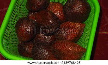 blurry and grainy picture of Salacca zalacca or Salacca edulis indonesian tropical fruit called as Salak or snake fruit has a brown color skin