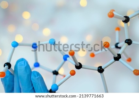 close-up of female scientist's hands holding model of molecular compounds on a blurred background, study of the human genome, concept scientific chemical innovation Royalty-Free Stock Photo #2139771663