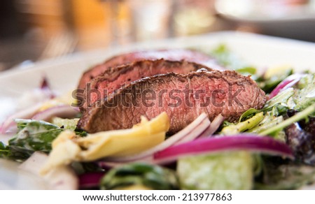 Steak and Greens Salad with Grass Fed Beef and Red Onions Royalty-Free Stock Photo #213977863