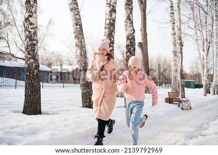 mother and daughter run merrily in the spring park. High quality photo
