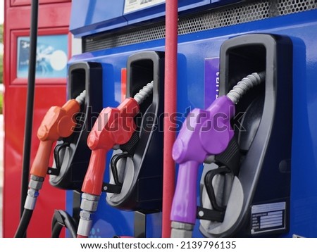 fuel dispenser. The purple fuel nozzles are arranged in several colors. Gasoline and diesel service stations. The purple fuel dispenser is installed in the blue oil dispenser. Fuel pumps gasohol. Royalty-Free Stock Photo #2139796135