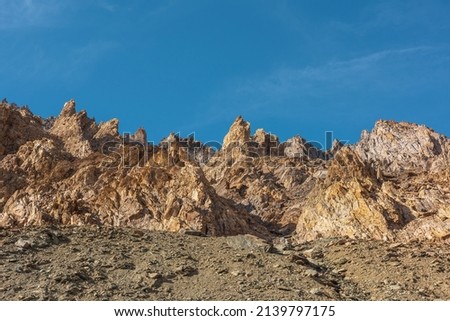 Scenic mountain landscape with sharp rocks under blue sky in sunny day. Colorful scenery with gold sunlit sharp rocky mountains. Sharp rocks in bright sun. High rocky mountains in golden sunlight. Royalty-Free Stock Photo #2139797175