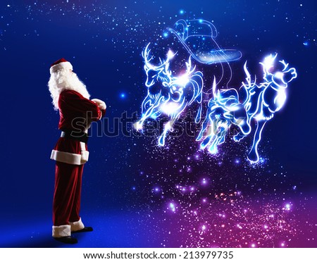 Santa claus looking at magic image of sledge with deer