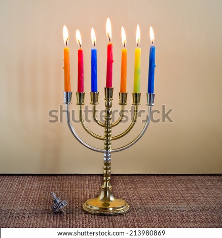 Hanukkah menorah with candles and silver dreidel.