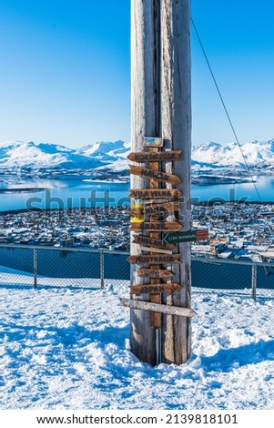 View point with sign post located at Fjellheisen cable car overlook, mountain Storsteinen in Tromsø, Norway
ci potrai trovare qui = you find us here
hoyspenning livsfare = high voltage risk of death