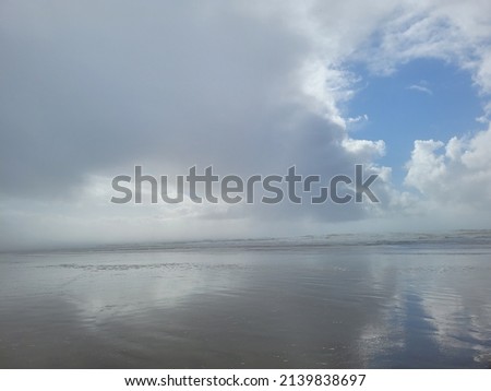 Wet sandy beach on a cloudy day.