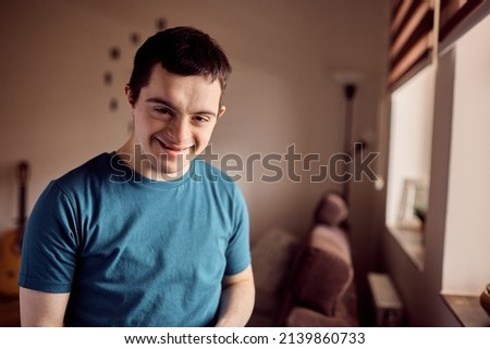 Young happy down syndrome man at home looking at camera. Royalty-Free Stock Photo #2139860733