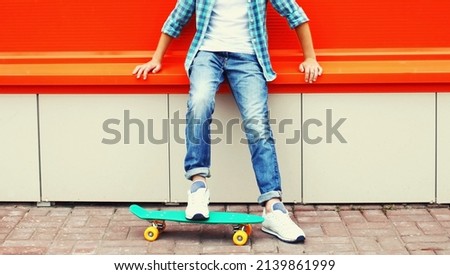 Teenager boy with skateboard on colorful red background