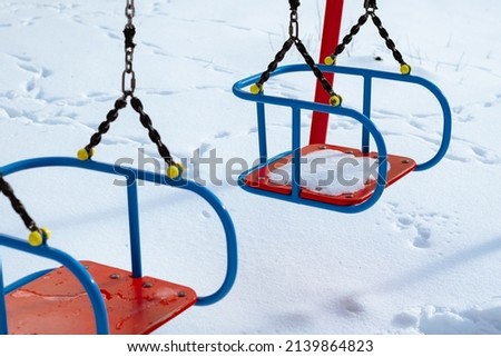 Empty swing at the playground in winter
