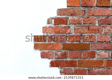 Decorative masonry made of red clay bricks. The texture of natural stone on the background of white plaster