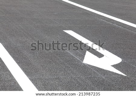 White traffic arrow signage  on an asphalt road