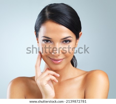 She has no doubt that her skincare regime is the best. Studio shot of a beautiful young woman against a blue background. Royalty-Free Stock Photo #2139872781