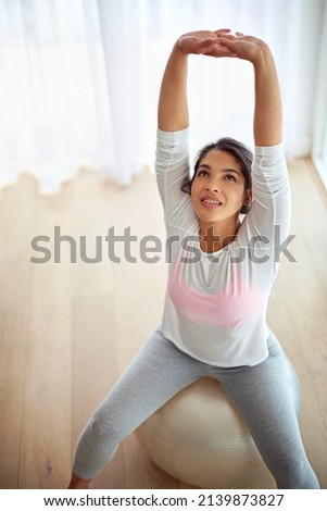 Stretch your limits. Shot of a young woman working out on a fitness ball.
