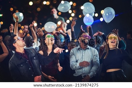 Its going down. Cropped shot of a diverse group of young friends having fun with balloons at a party at night. Royalty-Free Stock Photo #2139874275