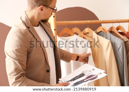 Young male clothes stylist working in studio Royalty-Free Stock Photo #2139880919