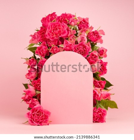 Fresh pink roses as framing of arch on abstract pink scene mockup for presentation cosmetic products or goods, square, closeup. Bright romantic summer template for advertising, design.