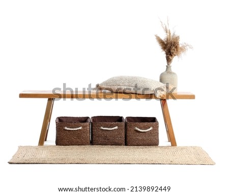 Wooden bench with pillow, vase, baskets and rug on white background Royalty-Free Stock Photo #2139892449