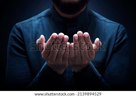 Muslim man praying on dark background Royalty-Free Stock Photo #2139894529