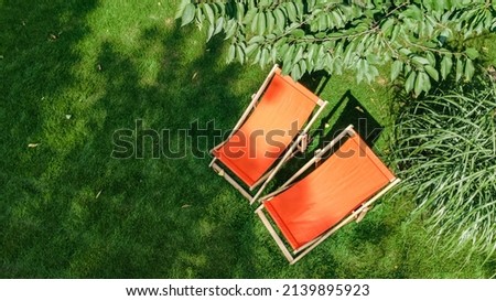 Summer garden with sunbed deckchairs on grass aerial top view, green park trees and place for relax from above Royalty-Free Stock Photo #2139895923