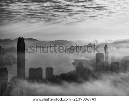 Skyscraper in downtown district of Hong Kong city in fog under sunrise