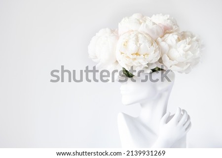 Fresh bunch of white peonies in vase in shape of womens face on light background. Trendy Ceramic Vase of human head, Handmade Modern Statue Art Flower Vase. Card Concept, copy space for text Royalty-Free Stock Photo #2139931269