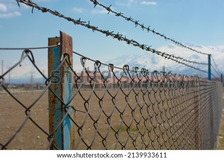 A prison surrounded by barbed wire. Captivity themed photo.