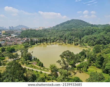 Malaysia nature pond, mountain and tropical greens view from 50metre view with blue and cloud sky. Selective focus.