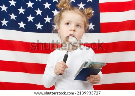 Little beautiful girl with American dollarsi the hands, Flag of America on background