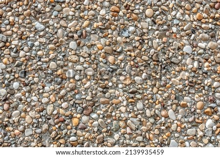 Small round stones background. Stone texture.  Rough surface of small pebble stone. Royalty-Free Stock Photo #2139935459