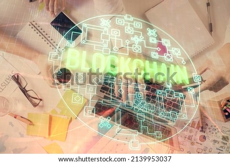 Double exposure of man's hands typing over computer keyboard and crypto currency theme hologram drawing. Top view. Blockchain concept.