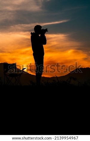 Photographer Ready to Take Sunset Pictures, dramatic sunset sky with young travel photographer, Photography day concept image