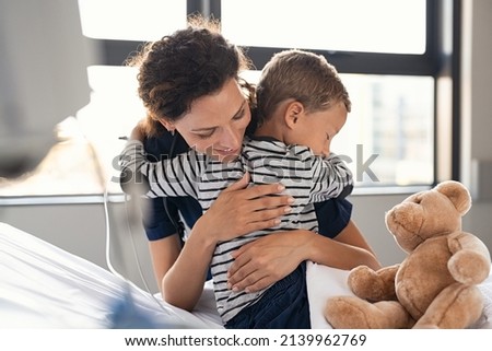 Nurse hugging sick little boy patient in hospital. Young medical practitioner embracing upset kid in clinic. Lovely doctor taking care of cute child at private clinic: gratitude and healthcare concept Royalty-Free Stock Photo #2139962769