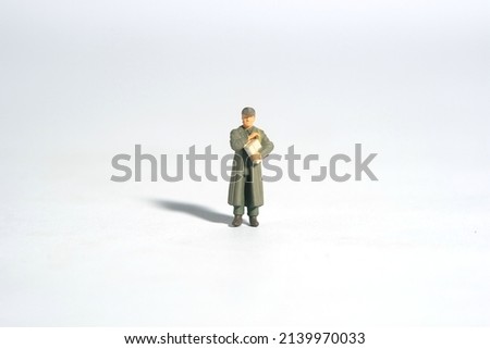 Miniature people toy figure photography. A military mail officer holding news pack. Isolated on white background. Image photo