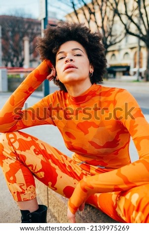 Young black woman outdoor posing outdoor in the city looking camera serious and confident