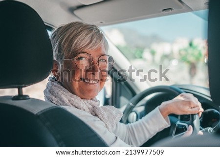 Happy owner. Handsome mature woman sitting relaxed in his newly bought car looking at the camera smiling joyfully. One old senior driving and having fun. Royalty-Free Stock Photo #2139977509