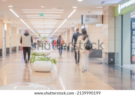 Abstract defocused motion blurred young people walking in shopping center, urban lifestyle concept. For background , backdrop