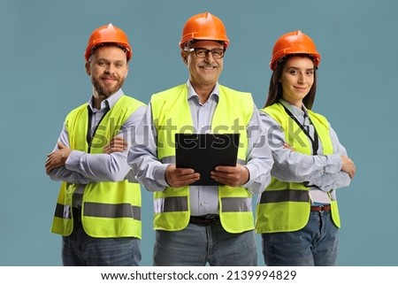 Team of three site engineers isolated on blue background Royalty-Free Stock Photo #2139994829
