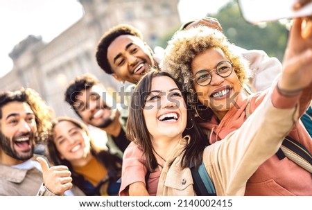 International guys and girls taking photo out side in Barcelona - Happy life style concept on young multiracial college students having fun day together at university campus - Bright faces warm filter