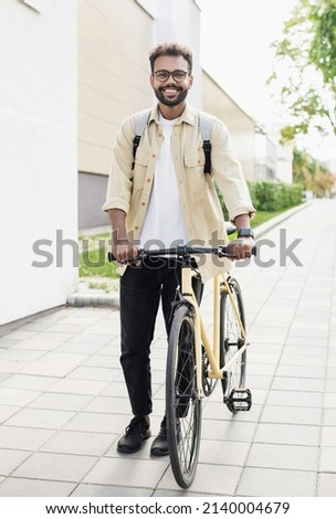 Smiling young man riding a bicycle on a city street, Active lifestyle, people concept