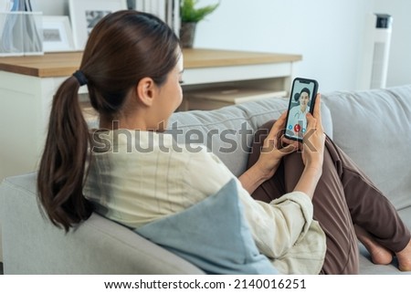 Asian young woman patient talking virtual online with medical doctor. Attractive physician man giving telehealth telemedicine video call for internet consult diagnosis treatment to sick girl at home. Royalty-Free Stock Photo #2140016251