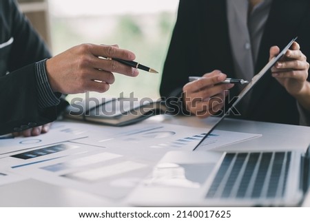 Close up of businessman or accountant hand holding pen working on calculator to calculate business data, accountancy document and laptop computer at office, business concept Royalty-Free Stock Photo #2140017625