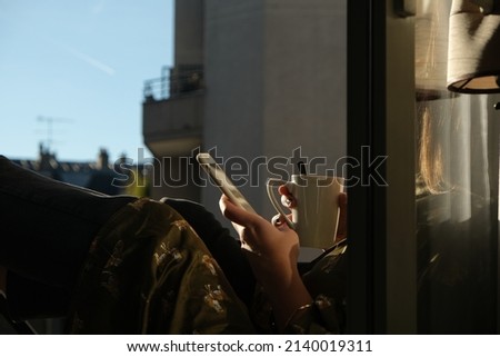 Sitting in window in Paris with coffee and iPhone
