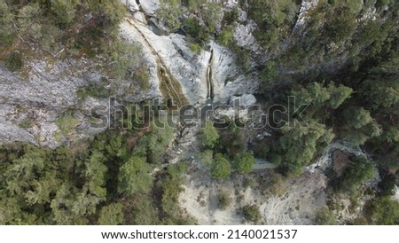 Two small waterfalls deep inside mountains aerial photo