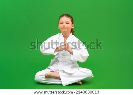 Martial arts classes, karate children's school, preparation for wrestling training, development of a child in martial arts, a girl in a white kimono.