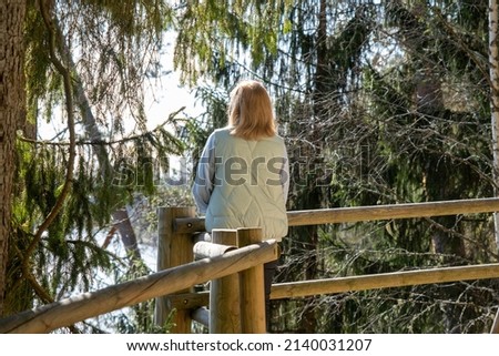 Woman viewing panorama over Gauja river bed at Gauja National Park near Valmiera, Latvia. View from Sietiniezis.