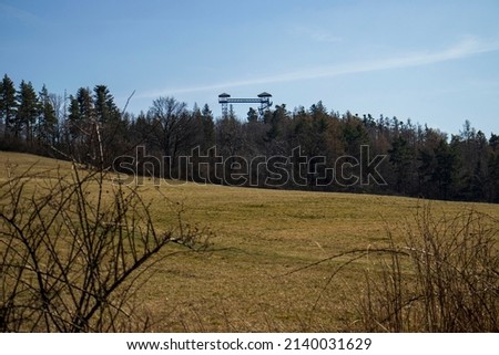 pictures of nature in the Czech Republic near the town Krnov. Grassy slope with forest in the distance and a protruding lookout tower