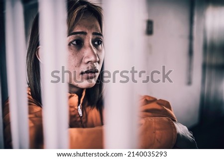 Portrait of women desperate to catch the iron prison,prisoner concept,thailand people,Hope to be free,If the violate the law would be arrested and jailed.