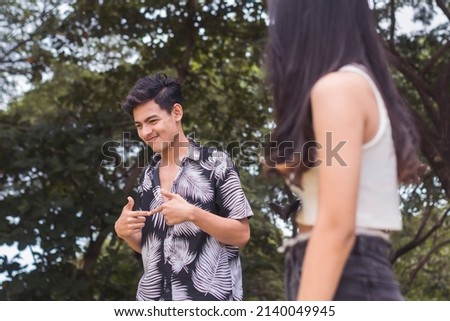 A cute young guy being shy while conversing with a girl. Interested to know the person but feeling anxious. Keeping his distance. Royalty-Free Stock Photo #2140049945
